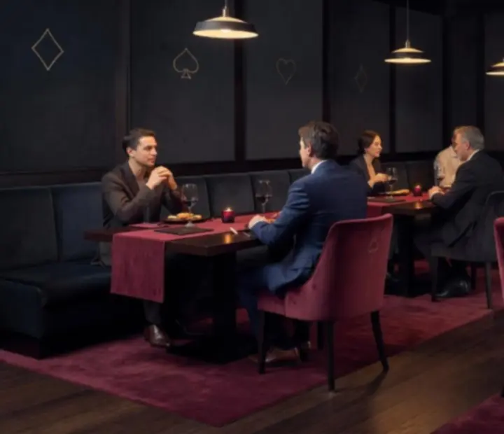 Atmospheric restaurant dining room with moody lighting and poker-inspired details